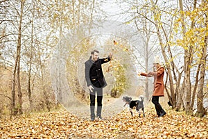 Couple walking with dog in the Park and hugging. Autumn walk men