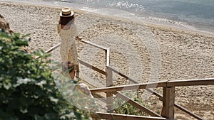 Couple walking down stairway on beautiful beach. Two lovers going to seashore.