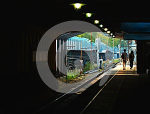 Couple walking on empty train station background