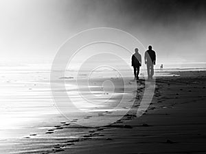 Couple walking on foggy beach