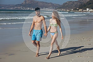 Couple walking with hand in hand at beach