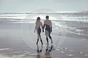 Couple walking with hand in hand at beach