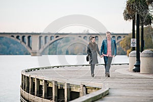 Couple walking hand in hand on the Georgetown Boardwalk