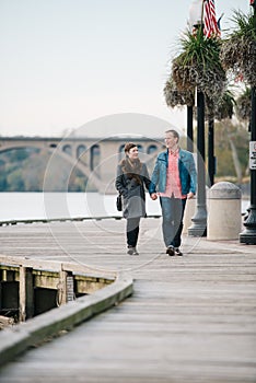 Couple walking hand in hand on the Georgetown Boardwalk