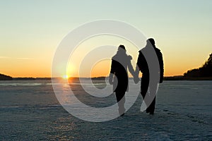 Couple walking on ice at sunset