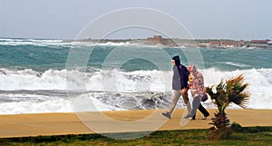 A couple walking near the sea in storm