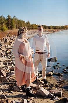 Couple walking near the water while waiting for the child