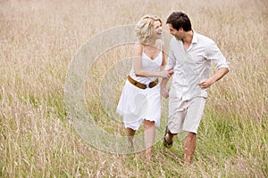 Couple walking outdoors holding hands smiling