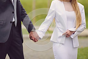 couple walking in park holding hands