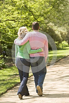 Couple walking on path arm in arm