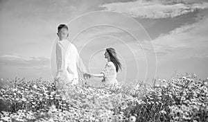 Couple walking in poppy field holding hands smiling, love and romance