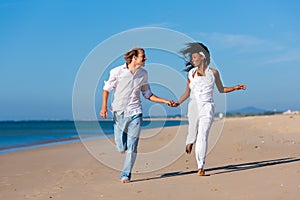 Couple walking and running on beach
