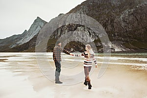 Couple walking together on beach holding hands