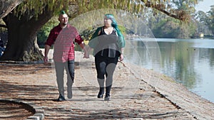 Couple walking towards camera and holding hands