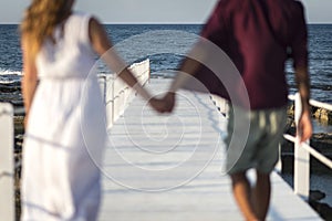 A couple walking on a white pier, during sunset photo