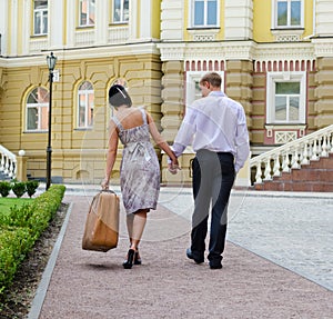 Couple walking with woman carrying luggage photo