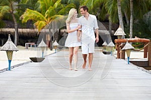 Couple Walking On Wooden Jetty