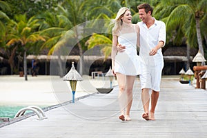 Couple Walking On Wooden Jetty