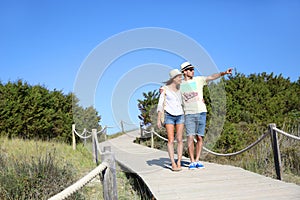 Couple walking on a wooden pontoon admiring nature