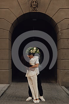 The couple walks around Kyiv. Old city. Love story. Walk around the city. A woman in a white suit. Guy in a t-shirt and jeans.