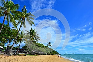 Couple walks on Trinity beach near Cairns Queensland Australia