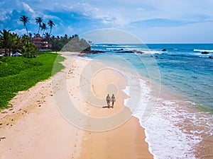 Couple walks on tropical sandy beach