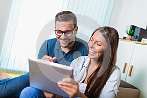 Couple watching media content online in a tablet in the living room
