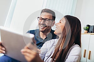 Couple watching media content online in a tablet in the living room