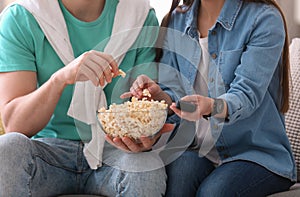 Couple watching movie with popcorn at home