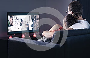 Couple watching movie or series. Online streaming and VOD service in tv screen. Film stream or television show. Cuddling.