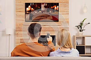 Couple watching romantic movie on TV in room