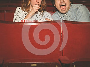 Couple watching a scary film in a movie theater