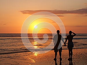 Couple watching the setting sun hand in hand