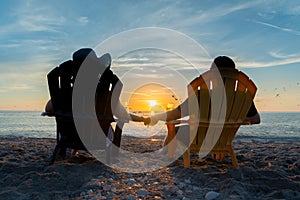 Couple Watching The Sunset On Beach