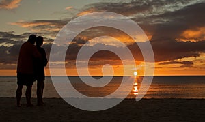 Couple watching sunset on the beach