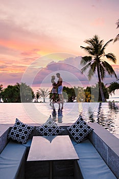 couple watching sunset in infinity pool on a luxury vacation in Thailand