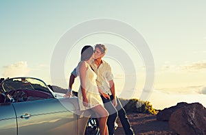 Couple Watching the Sunset and Kissing with Classic Vintage Car
