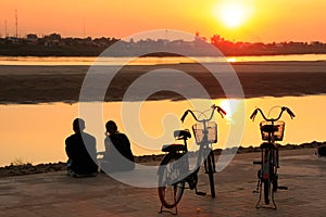 Couple watching sunset at Mekong river