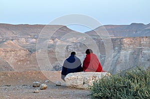 Couple watching the sunset over the Negev desert, Israel photo