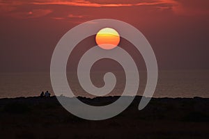 Couple watching the sunset in the sea