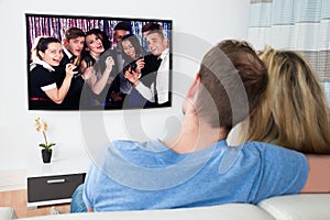 Couple watching television at home