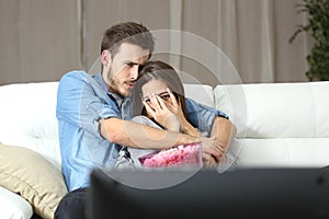 Couple watching terror tv movie at home