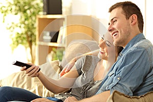 Couple watching tv on a couch at home