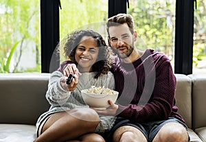 Couple watching TV having popcorn