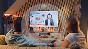 Couple watching TV news about polio in water