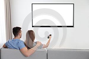 Couple watching TV on sofa at home