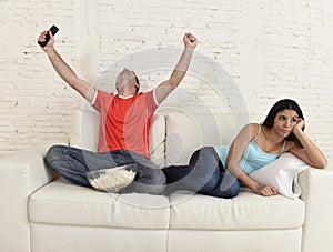 Couple watching tv sport football with man excited celebrating