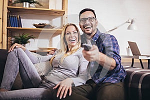 Couple is watching tv together and having fun in the living room