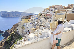 Couple watching the view of cityscape of Oia village in Santorini