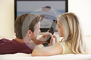 Couple Watching Widescreen TV At Home